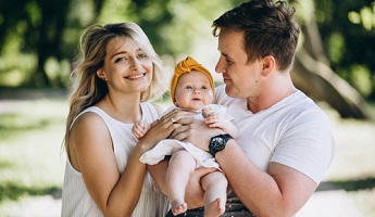 young couple with newborn in an italian style garden